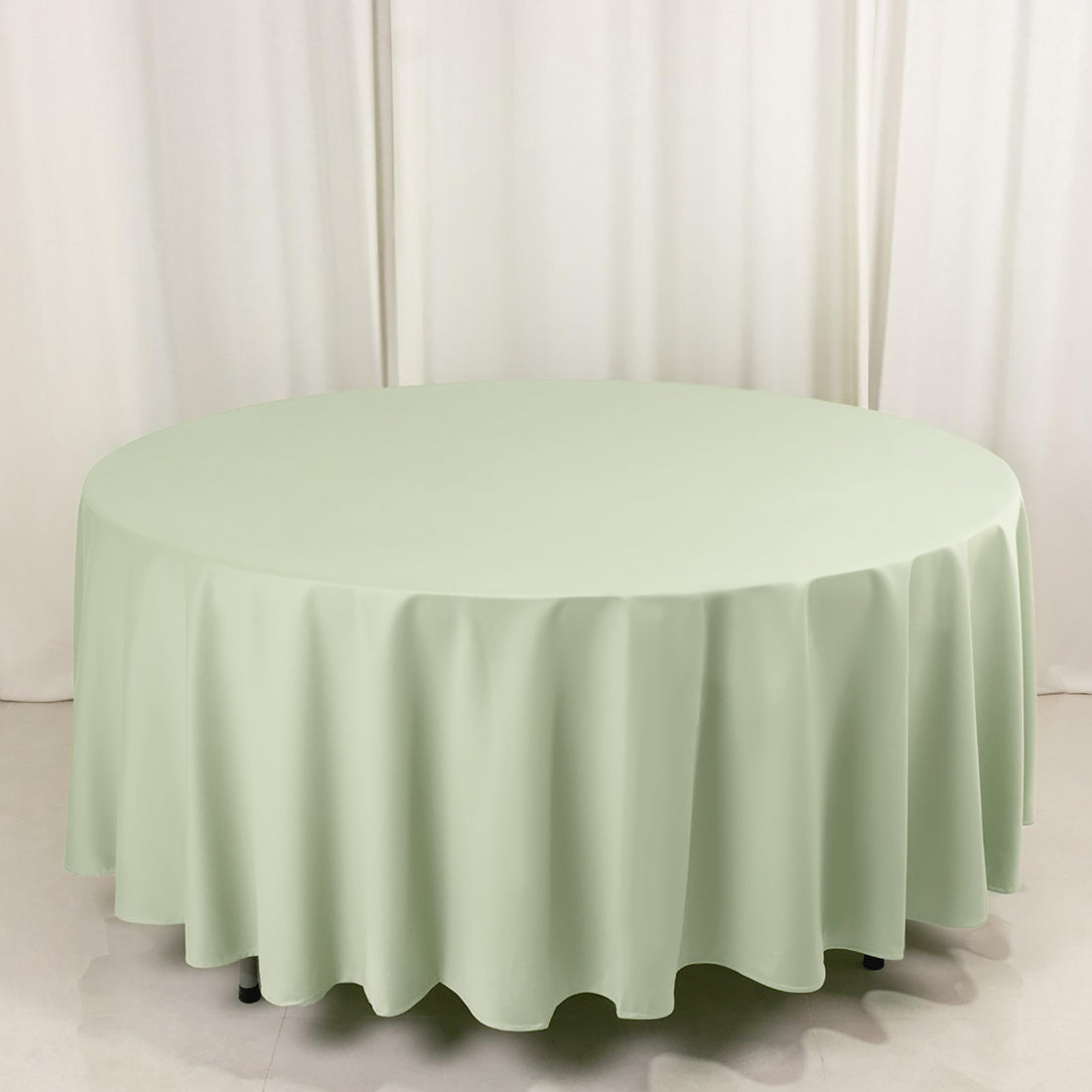 Round mint green tablecloth on a white backdrop