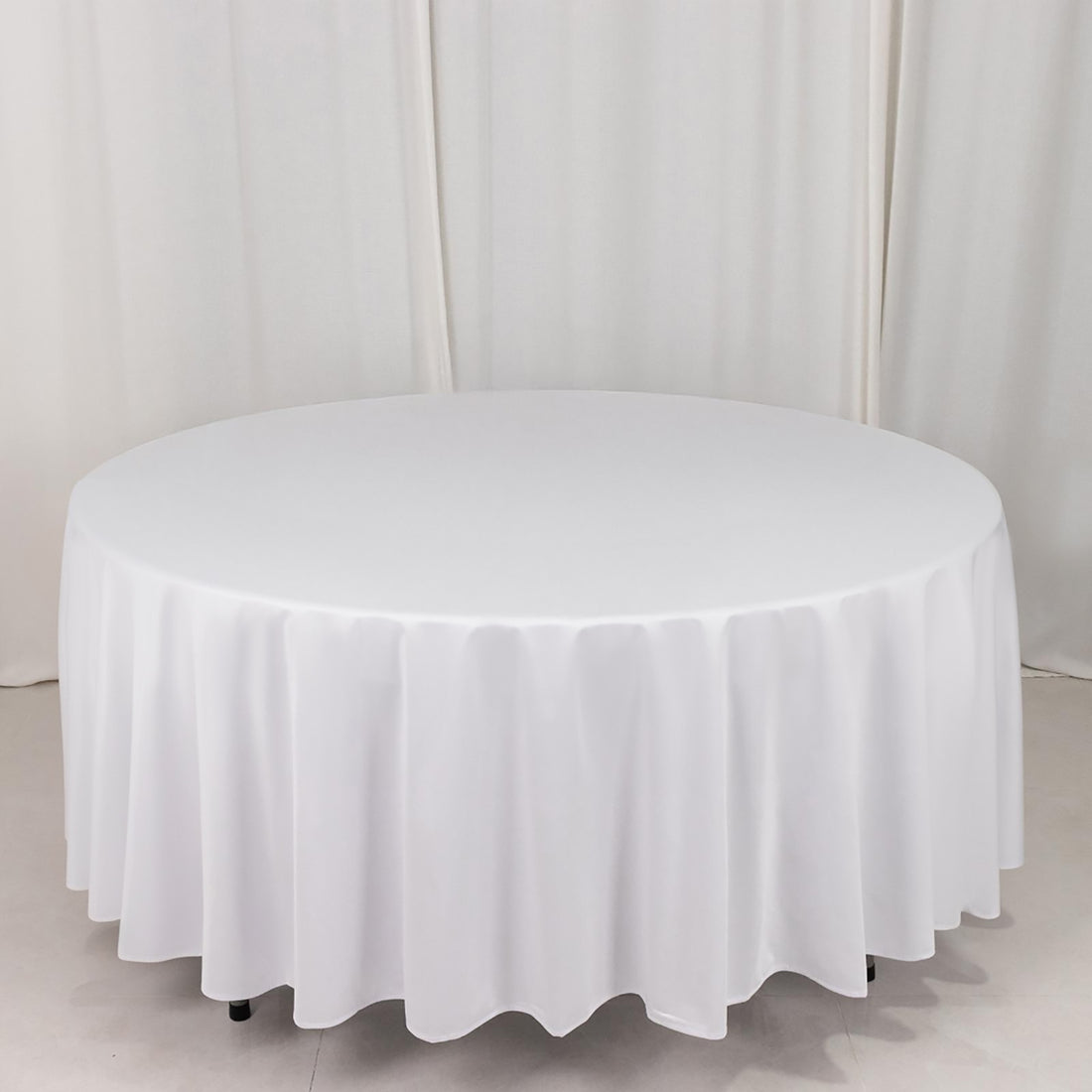 White round tablecloth with elegant draping on a circular table