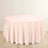 Round pink tablecloth on a wooden floor.