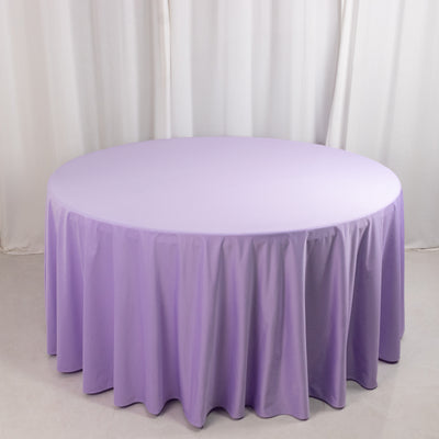 Purple round tablecloth with elegant draping on a plain backdrop.