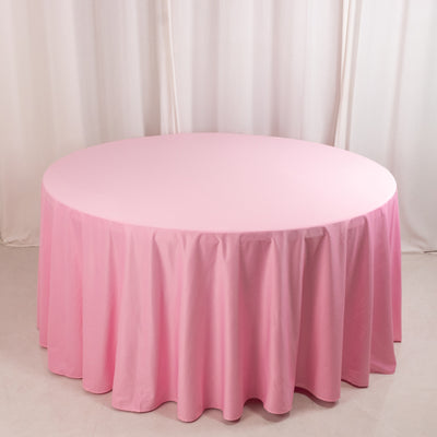 Round pink tablecloth draping elegantly over a circular table.