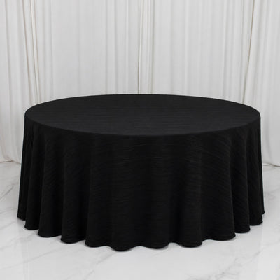 Black round banquet table with elegant draped tablecloth on white backdrop