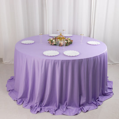 Round lavender tablecloth with decorative plates and floral centerpiece