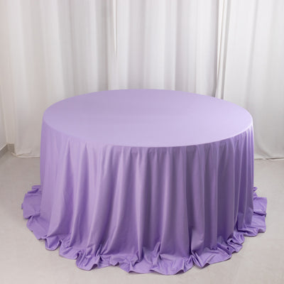 Round lavender tablecloth with draped edges on a plain backdrop.