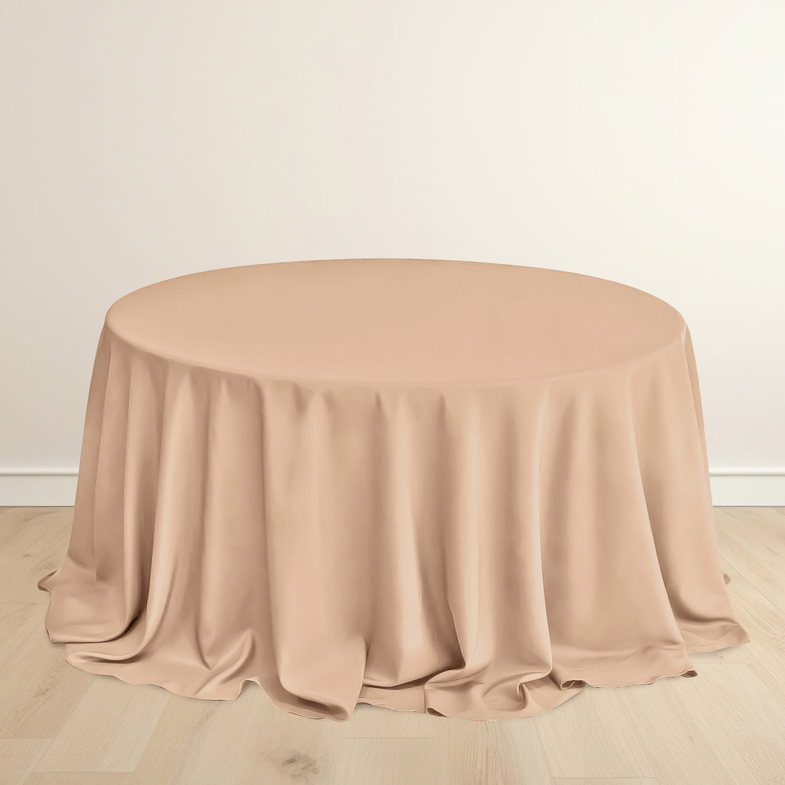 Round beige table with draped fabric on a plain background.