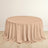 Round beige table with draped fabric on a plain background.