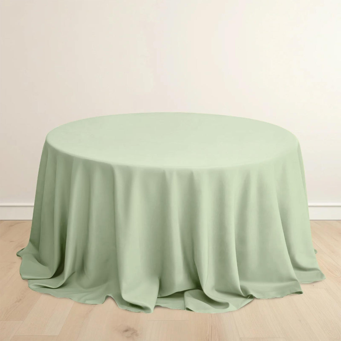Round mint green tablecloth on a plain backdrop