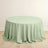 Round mint green tablecloth on a plain backdrop