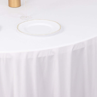 Elegant white table setting with a gold-trimmed plate and glass.