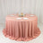 Pink round table with white plates and glasses in elegant event setup