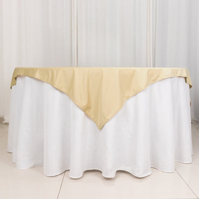 Gold table cover draping over a white tablecloth in a studio setting.