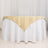 Gold table cover draping over a white tablecloth in a studio setting.