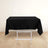 Black tablecloth draped over a white folding table in a minimalist setting.
