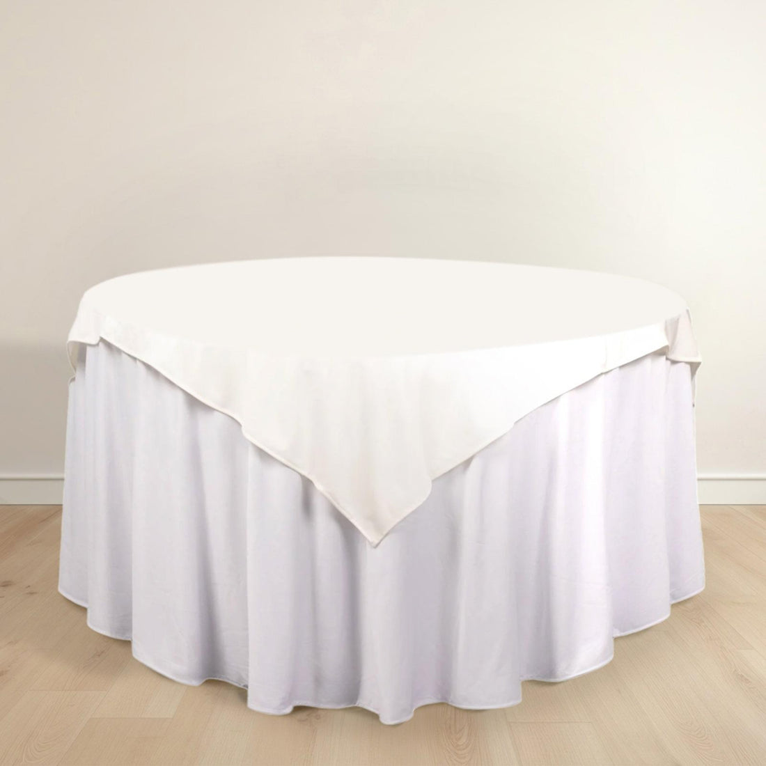 Round table with a white tablecloth draping elegantly around the edges.