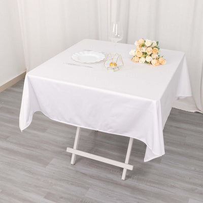 Elegant white table setting with flowers and glassware.