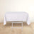 White tablecloth draped over a folding table on a light wooden floor.