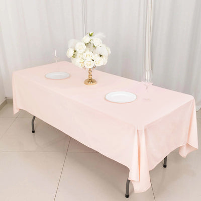Elegant pink tablecloth draped over a table with floral centerpiece and dinnerware.