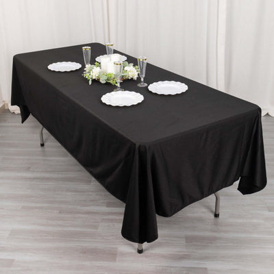 Black tablecloth draped over a table with decorative plates and centerpieces.