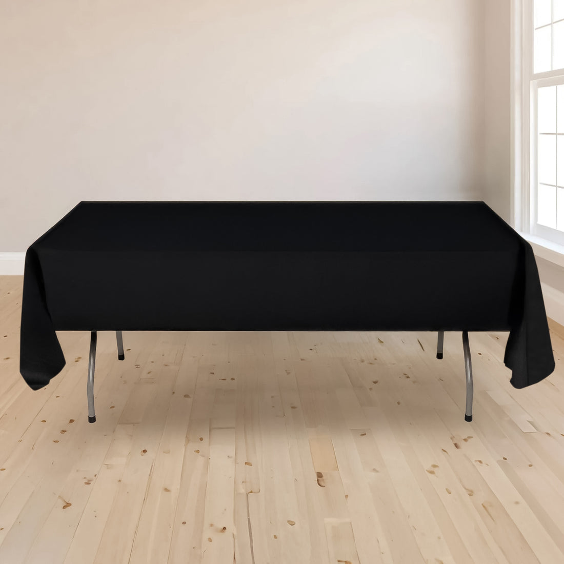 Black tablecloth draped over a folding table in a bright room.