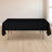 Black tablecloth draped over a folding table in a bright room.
