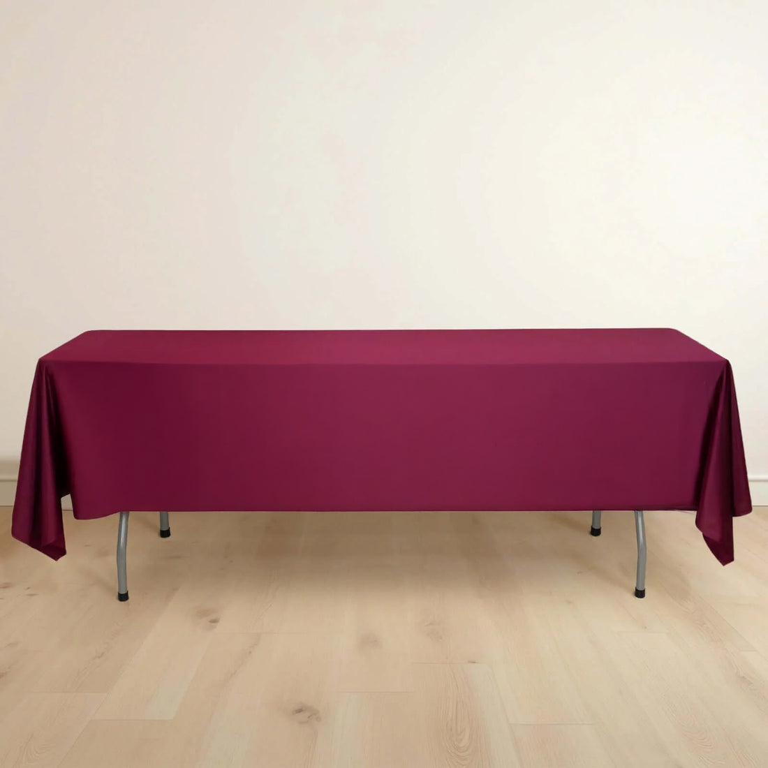 Burgundy tablecloth draped over a table in a minimalist setting.