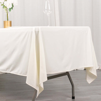 White tablecloth draped elegantly over a table with a glass and flower vase.