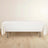 White table with a tablecloth on a light wooden floor.