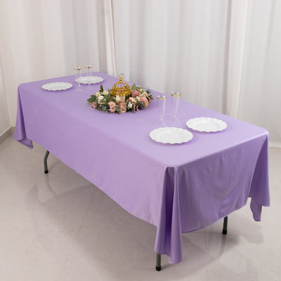 Purple tablecloth draped over a table with decorative plates and floral centerpiece.