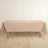 Beige tablecloth draped over a folding table on a light wooden floor.