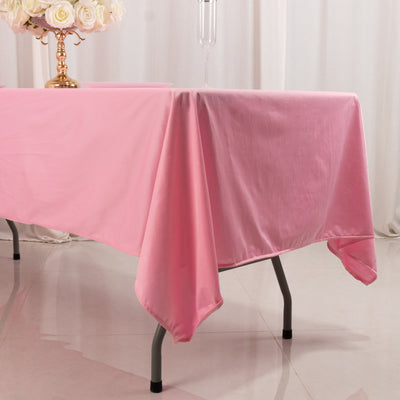 Pink tablecloth draped over a table with a floral centerpiece.