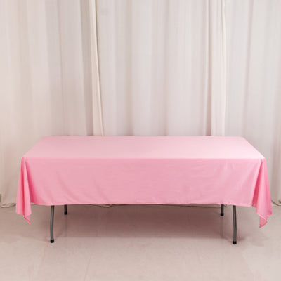Pink tablecloth draped over a folding table in a studio setting.