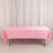 Pink tablecloth draped over a folding table in a studio setting.