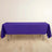 Purple tablecloth draped over a table on a wooden floor.