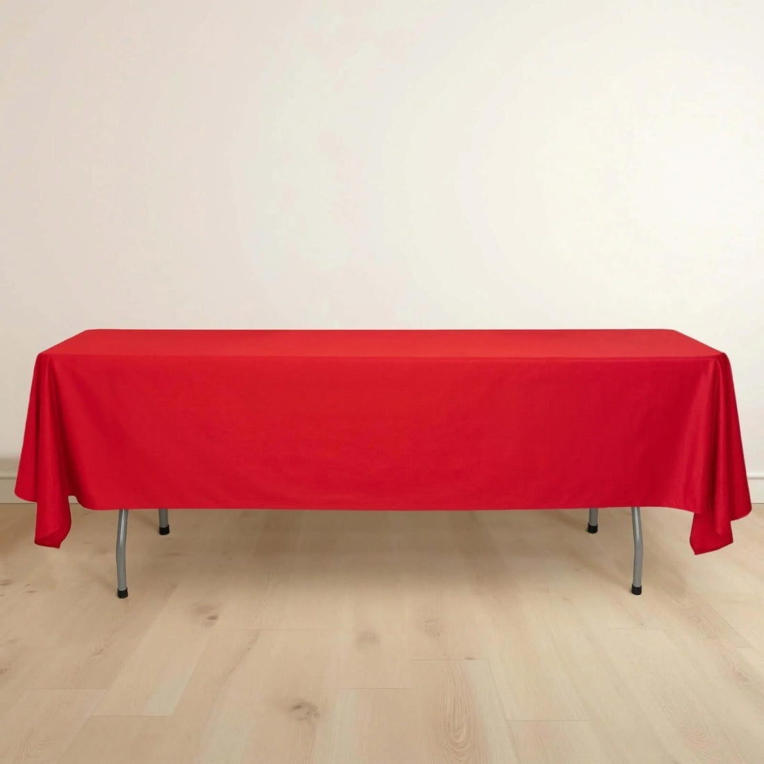 Red tablecloth draped over a folding table on a plain background.