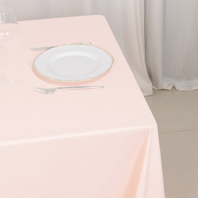 Elegant pink tablecloth with fine china plate and cutlery set.