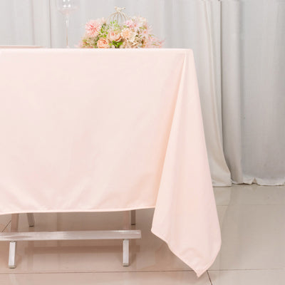 Pink tablecloth draped over a table with floral arrangement in a soft setting.