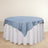 Round table with a blue tablecloth and white skirt