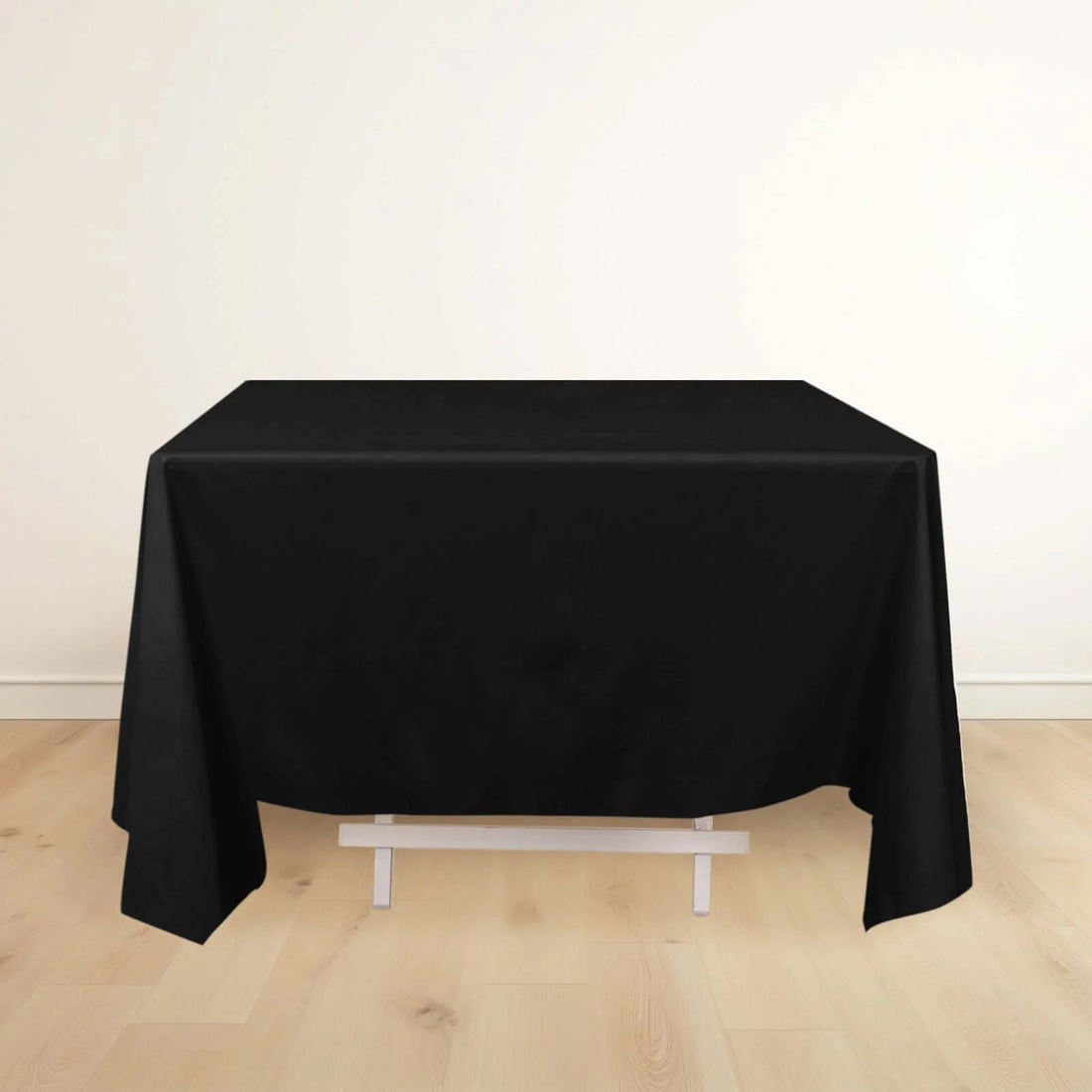 Black tablecloth draped over a table in a studio setting.