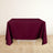 Burgundy tablecloth draped over a table on a light wooden floor.