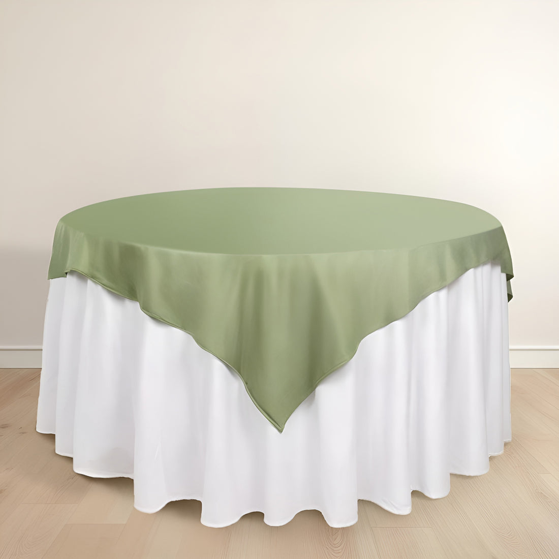 Round table with green satin overlay and white tablecloth.