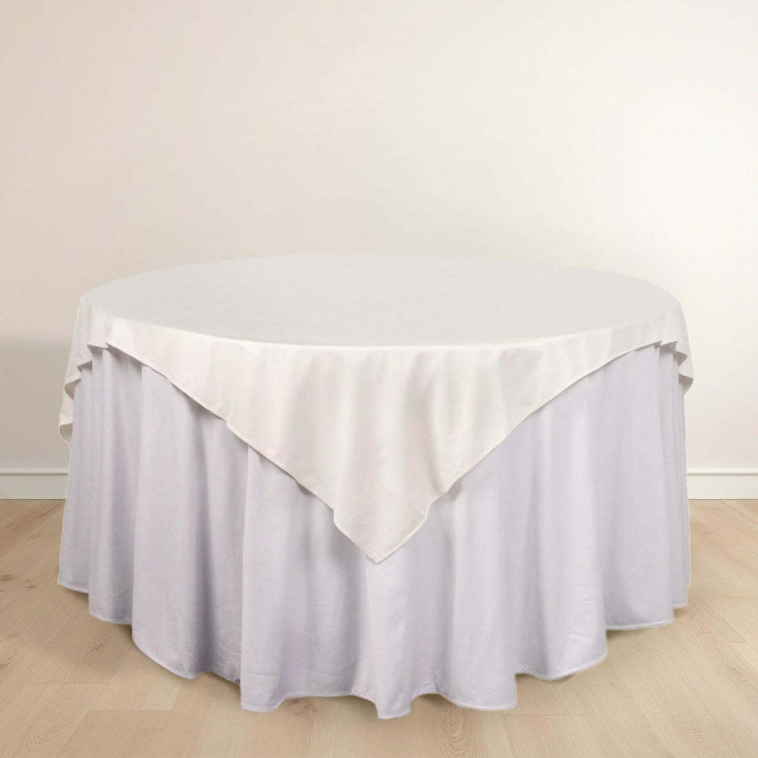 Round table with a white tablecloth draped elegantly over the edge.