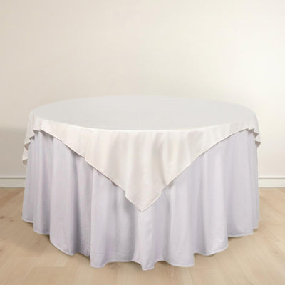 Round table with a white tablecloth draped elegantly over the edge.