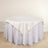 Round table with a white tablecloth draped elegantly over the edge.
