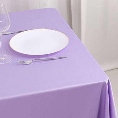 Purple tablecloth with a white plate and silver utensils on a dining table.