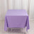 Purple tablecloth draped over a table on a plain backdrop.