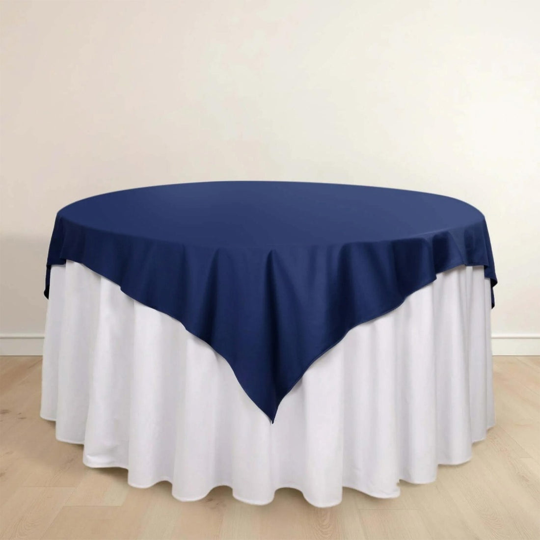 Navy tablecloth draped over a round table with a white skirt.