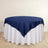 Navy tablecloth draped over a round table with a white skirt.