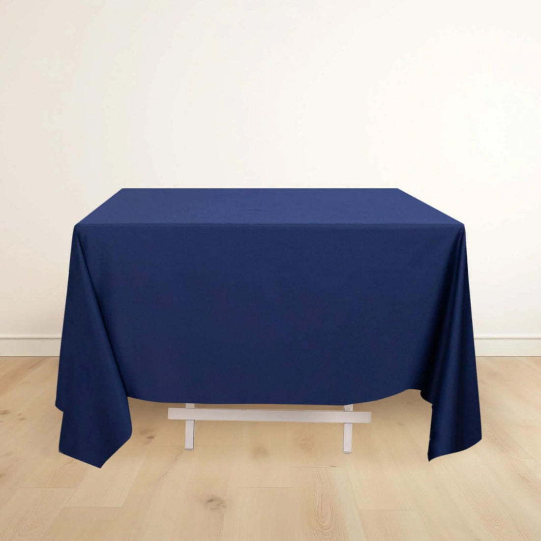 Navy tablecloth draping over a table in a minimalist setting.