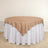 Round table with a beige cloth draped over a white table skirt.