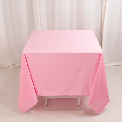 Pink tablecloth draped over a table in a studio setting